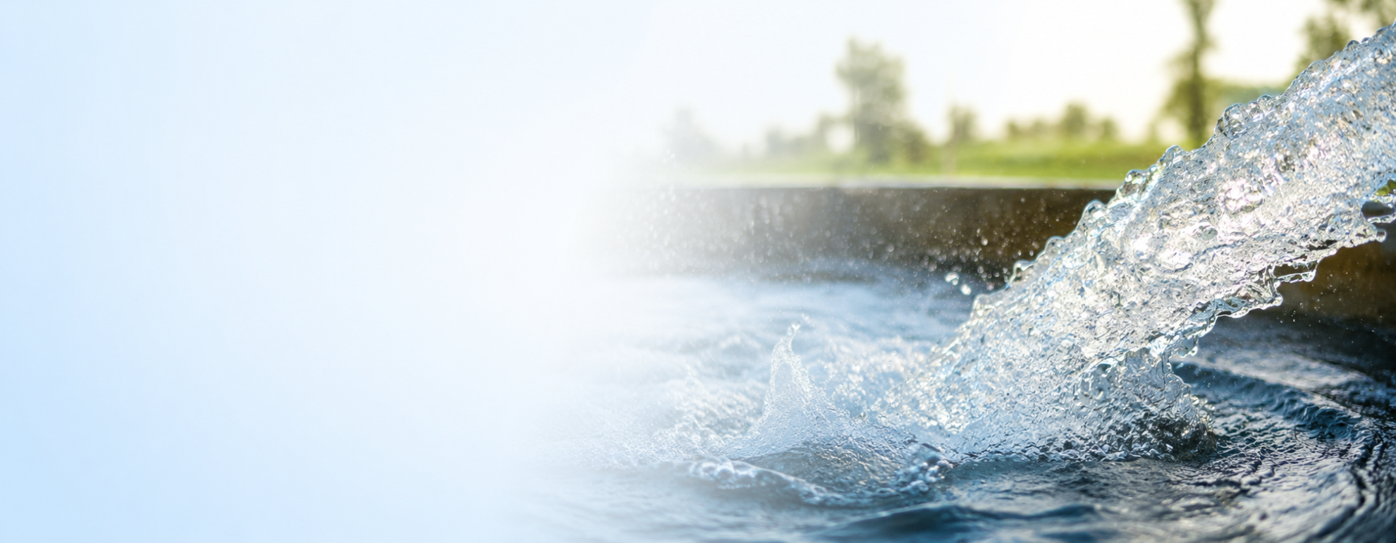 Clear well water flowing into a basin on a sunny day